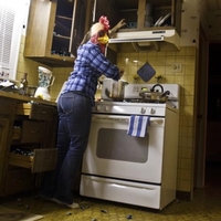 woman in kitchen and her head is that of a chicken